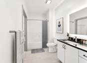 Thumbnail 21 of 26 - A bathroom with a toilet, sink, and shower at The Point Apartments on 38th, Norfolk, Virginia