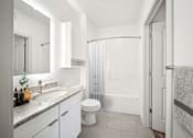 Thumbnail 17 of 25 - A white bathroom with a toilet, sink, and shower at Circ Apartments, Virginia