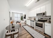 Thumbnail 13 of 25 - A modern kitchen with a dining table and chairs at Circ Apartments, Virginia