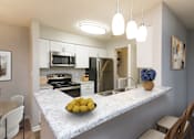 Thumbnail 21 of 21 - A kitchen with a marble countertop and a bowl of lemons on it.