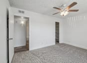 Thumbnail 10 of 26 - A room with a ceiling fan and carpeted floor.
