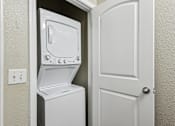 Thumbnail 25 of 25 - A white dryer is in a small space next to a door.