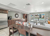 Thumbnail 18 of 26 - A modern kitchen with a dining table and chairs.