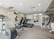 Thumbnail 20 of 26 - A gym with treadmills, elliptical machines, and other exercise equipment.