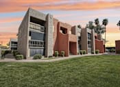 Thumbnail 16 of 26 - A modern building with a green lawn in front.