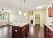 Thumbnail 17 of 22 - A kitchen with brown cabinets and a countertop at Overlook at Stone Oak Park Apartments, San Antonio