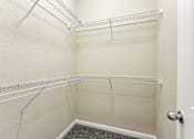Thumbnail 20 of 22 - A white closet with a door and a carpeted floor at Overlook at Stone Oak Park Apartments, San Antonio