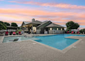 Thumbnail 24 of 25 - Evening View of Pool Clubhouse Fireplace Lounge Outside at Overlook at Stone Oak Park Apartments, San Antonio, 78258