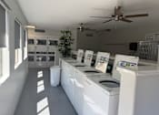 Thumbnail 15 of 29 - A laundromat with washers and dryers lined up.
