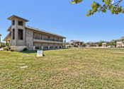 Thumbnail 44 of 45 - A grassy field with a building and a sign in the foreground.