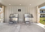 Thumbnail 43 of 45 - Two large stainless steel ovens are installed in a covered outdoor kitchen.
