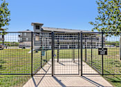 Thumbnail 42 of 45 - A black metal gate with a sign that reads "DOG PARK BREAK" in front of a building.
