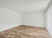 Thumbnail 7 of 26 - A room with wooden flooring and white walls.