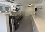 Thumbnail 17 of 29 - A laundry room with a washer and dryer, a fan, and a sink.