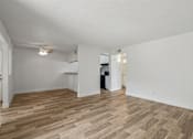Thumbnail 9 of 26 - A room with wooden flooring and white walls.