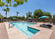 Thumbnail 2 of 10 - our resort style pool is filled with lounge chairs and umbrellas