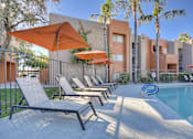 Thumbnail 24 of 26 - A poolside area with sun loungers and umbrellas.