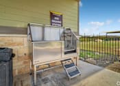 Thumbnail 11 of 22 - A dog washing station is located outside a building at Overlook at Stone Oak Park Apartments, San Antonio