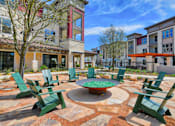 Thumbnail 1 of 35 - A courtyard with a fire pit and chairs at Park at Rialto Apartments, San Antonio