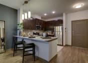 Thumbnail 14 of 35 - MODEL - Kitchen with Granite Counters & Stainless Steel Appliances at Park at Rialto Apartments, San Antonio