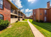 Thumbnail 10 of 11 - Wide Walkway Between Apartment Buildings at Oaks of Westlakes Apartments, San Antonio, TX