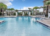 Thumbnail 4 of 46 - a large swimming pool with chaise lounge chairs and palm trees in the background