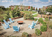 Thumbnail 25 of 48 - an outdoor patio with blue chairs and a fire pit