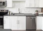 Thumbnail 32 of 48 - a kitchen with white cabinets and a stainless steel dishwasher