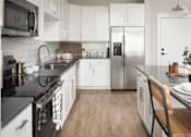 Thumbnail 35 of 48 - a kitchen with white cabinets and a stainless steel refrigerator