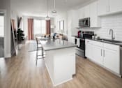 Thumbnail 36 of 48 - a white kitchen with a large island in the middle