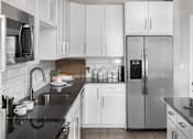 Thumbnail 3 of 48 - a kitchen with white cabinets and a stainless steel refrigerator