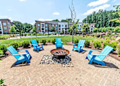 Thumbnail 46 of 48 - an outdoor seating area with blue chairs and a fire pit