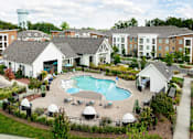 Thumbnail 9 of 48 - an aerial view of an outdoor pool with apartments in the background