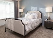 Thumbnail 54 of 60 - Bedroom with upholstered bed and nightstand lamps at Avli At Crosstown Center Apartments, TAMPA