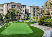 Thumbnail 56 of 60 - Putting green with seating area and tropical landscaping at Avli At Crosstown Center Apartments, TAMPA, FL