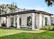 Thumbnail 51 of 60 - Outdoor clubhouse with covered porch and open lawn at Avli At Crosstown Center Apartments, TAMPA, Florida