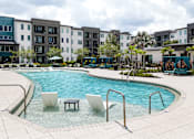 Thumbnail 34 of 60 - Swimming pool with tanning ledge and apartment buildings at Avli At Crosstown Center Apartments, Florida, 33619