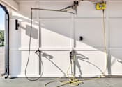 Thumbnail 43 of 60 - Garage workspace with retractable hose reels at Avli At Crosstown Center Apartments, TAMPA, FL