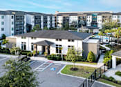 Thumbnail 32 of 60 - Clubhouse entrance with accessible parking and landscaping at Avli At Crosstown Center Apartments, Florida