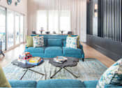 Thumbnail 39 of 60 - Open concept living and dining room with blue sofa at Avli At Crosstown Center Apartments, TAMPA, FL