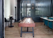 Thumbnail 38 of 60 - Game room with shuffleboard table and lounge seating at Avli At Crosstown Center Apartments, TAMPA, 33619