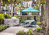 Thumbnail 3 of 60 - Outdoor patio with grill station and dining furniture at Avli At Crosstown Center Apartments, TAMPA, 33619