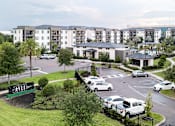 Thumbnail 18 of 60 - Gated property entrance with modern amenity buildings at Avli At Crosstown Center Apartments, Florida