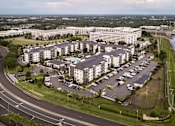 Thumbnail 20 of 60 - Aerial view of apartment community with parking and office buildings at Avli At Crosstown Center Apartments, Florida, 33619