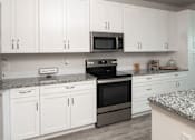 Thumbnail 25 of 60 - Modern kitchen with stainless steel appliances and island at Avli At Crosstown Center Apartments, TAMPA, 33619