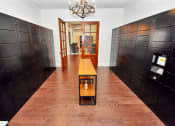 Thumbnail 46 of 54 - a long hallway with dark brown lockers and a small table