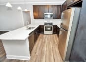 Thumbnail 49 of 54 - a kitchen with dark wood cabinets and white countertops