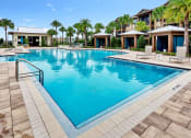 Thumbnail 15 of 46 - a resort style swimming pool with lounge chairs and palm trees in the background