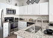 Thumbnail 4 of 31 - Kitchen with black appliances at Manchester Place Apartments, Lithia Springs