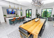Thumbnail 20 of 46 - a clubhouse dining room with a long wooden table and black chairs